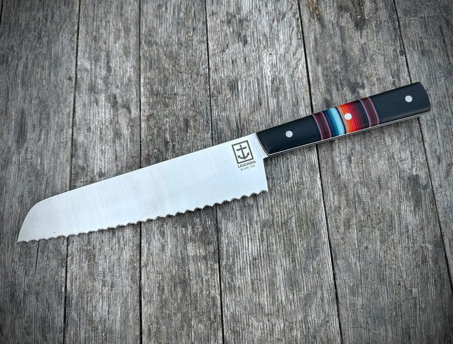 Serrated knife with a multicolored handle on a wooden surface